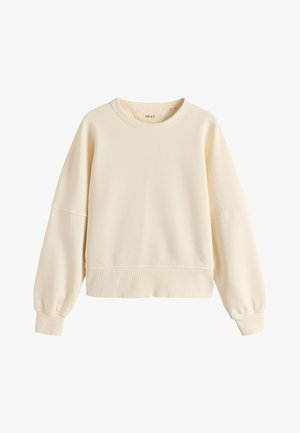 Krém színű környakas pulóver hosszú ballon ujjakkal és bordázott mandzsettákkal, valamint alsó résszel, egyszerű, hétköznapi stílus.