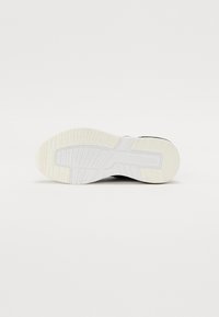 Texturált fehér gumiból készült sneaker talp, amely tapadást biztosít, letisztult dizájnnal és tartós felépítéssel a stabilitás érdekében.