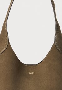 Olive green suede handbag with a smooth finish, curved top, and a subtle gold logo on the front. Stitched edges detail the design.