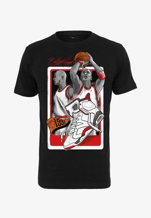 T-shirt noir avec des illustrations graphiques de joueurs de basket-ball en uniformes blancs et rouges, accompagnées d'une sneaker détaillée blanche et rouge.