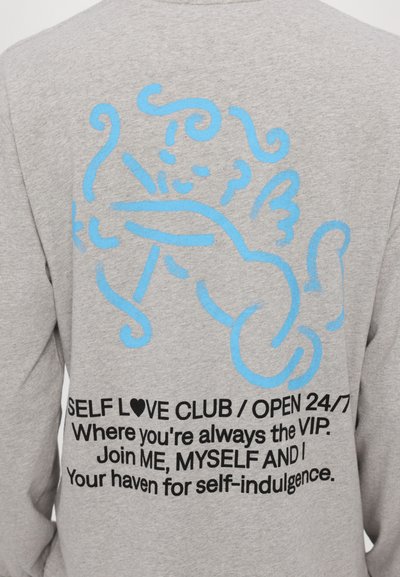 Gray sweatshirt with a large blue graphic of a cherub on the back. Text below reads "SELF LOVE CLUB / OPEN 24/7" in bold black letters.
