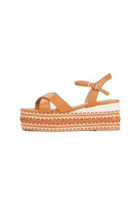 Brown leather platform sandals with cross straps and ankle buckle. Features braided jute midsole and white stitching accents.