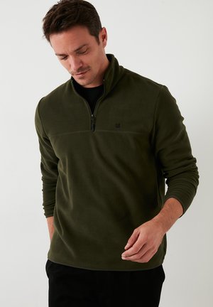 Olive green fleece pullover with a half-zip collar, textured fabric, and a logo on the chest. Features long sleeves and a relaxed fit.