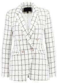 White double-breasted blazer with a textured fabric, featuring a black grid pattern, gold button accents, and two front pockets.