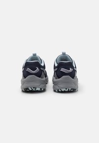 Zapatillas de correr de color navy con parte superior de malla, acentos de color azul claro y una entresuela gris. Presentan una suela exterior texturizada con un patrón en negro y azul claro.