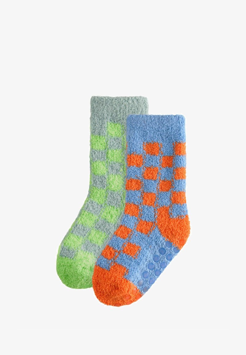 Chaussettes douces avec un motif à carreaux vert et gris sur une chaussette et un motif à carreaux bleu et orange sur l'autre. Dots antidérapants sur les semelles.