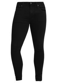 Musta deniminäyttöiset skinny-farkut, joissa on sileä pinta. Niissä on viisi taskua, napillinen ja vetoketjullinen suljenta sekä kapea istuvuus.