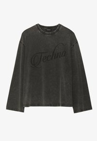 Musta, ylipitkä pitkähihainen paita, joka on valmistettu puuvillasta. Ominaisuuksiin kuuluu haalistunut pinta ja sana "Techno" painettuna isolla kursiivilla paidan etuosassa.