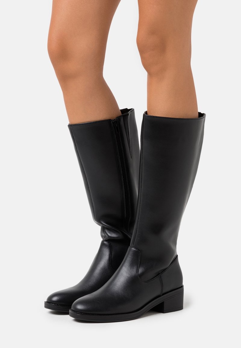 Bottes noires montant jusqu'au genou, fabriquées en cuir synthétique lisse, avec un bout arrondi, un petit talon carré et une fermeture éclair sur le côté pour un enfilage facile.