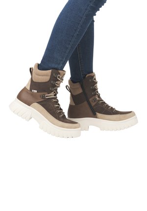 Bottes à lacets marron et beige avec une cheville haute, en matériaux textile et cuir, dotées d'une épaisse semelle blanche et d'un détail de fermeture éclair sur le côté.