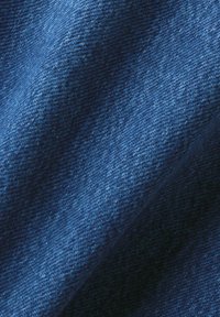 Mörkblå denimtyg med twill-bindning, som uppvisar en slät textur och svag lyster, med subtila nyansvariationer.