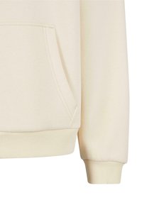 Manche de sweat-shirt beige et poche kangourou avec bord-côte aux poignets et à l'ourlet, présentées sur un fond uni.