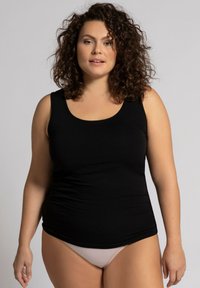 Top senza maniche nero realizzato in tessuto liscio, con scollatura rotonda e forma aderente, abbinato a bikini di colore chiaro.