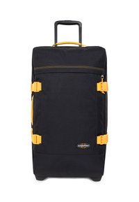 Musta matkalaukku, jossa keltaisia yksityiskohtia. Siinä on ulosvedettävä kahva, kaksi sivulenkkaria, suuri pääosasto ja kestävä kangaspinta.