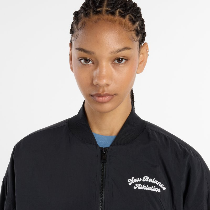 Black bomber jacket with a zip front, ribbed collar, and embroidered "New Balance Athletics" logo on the chest. Lightweight fabric, smooth texture.