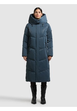 Puhasta, do koljena dužine u tirkiznoj boji, s visokim ovratnikom, kapuljačom i dva bočna džepa. Dizajn uključuje prošivene dijelove i kopče na drukere.