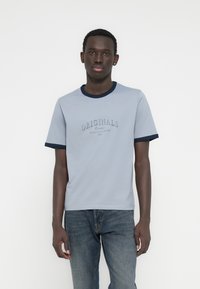 Ανοιχτό μπλε μπλουζάκι με σκούρο μπλε ριμπ λαιμόκοψη και μανσέτες, με κεντημένο το κείμενο «ORIGINALS» στο στήθος. Ομαλό βαμβακερό ύφασμα.