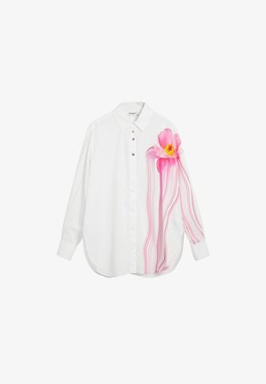 Weiße Hemdbluse mit großem pinkfarbenem Blumendesign auf einer Seite, mit pinken Akzenten und fließenden Linien, langen Ärmeln und geschwungenem Saum.