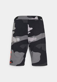 Svarta och grå kamouflage-shortsen har ett texturerat tyg. De har ett elastiskt midjeband och en liten röd logotyp på vänster sida.