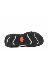 Semelle de chaussure en caoutchouc noir avec un motif de grip texturé, des reliefs prononcés et un accent central orange avec un design hexagonal.