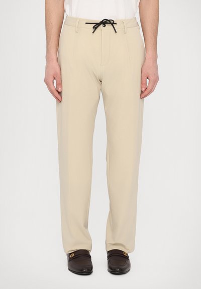 Pantalons beiges en tissu léger avec une taille élastique à cordon. Comprend deux poches avant et un design à jambes droites.