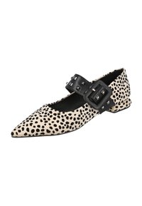 Zapato plano de punta afilada en color beige con un patrón de manchas negras. Presenta una correa con hebilla con tachuelas negras y un tacón bajo. Diseño de tela texturizada.