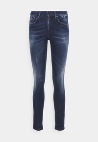 Jeans skinny de mezclilla en azul oscuro, con un lavado descolorido, diseño de cinco bolsillos y cierre de botón en la parte frontal.