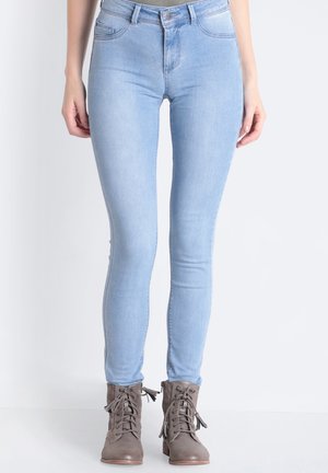 Lichtblauwe skinny jeans van denim, met hoge taille, vijf zakken en een gladde textuur, gecombineerd met grijze veterschoenen tot de enkel.