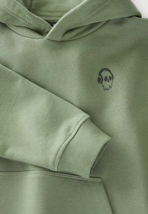 Hoodie en coton vert avec une poche avant. Présente un petit graphique de crâne noir avec des écouteurs sur la poitrine gauche. Texture lisse, poignets côtelés.