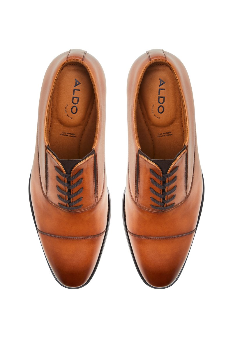 Chaussures habillées en cuir marron avec une finition lisse, dotées d'un bout pointu, de surpiqûres ton sur ton et de détails en lacet noir. Marque ALDO à l'intérieur.