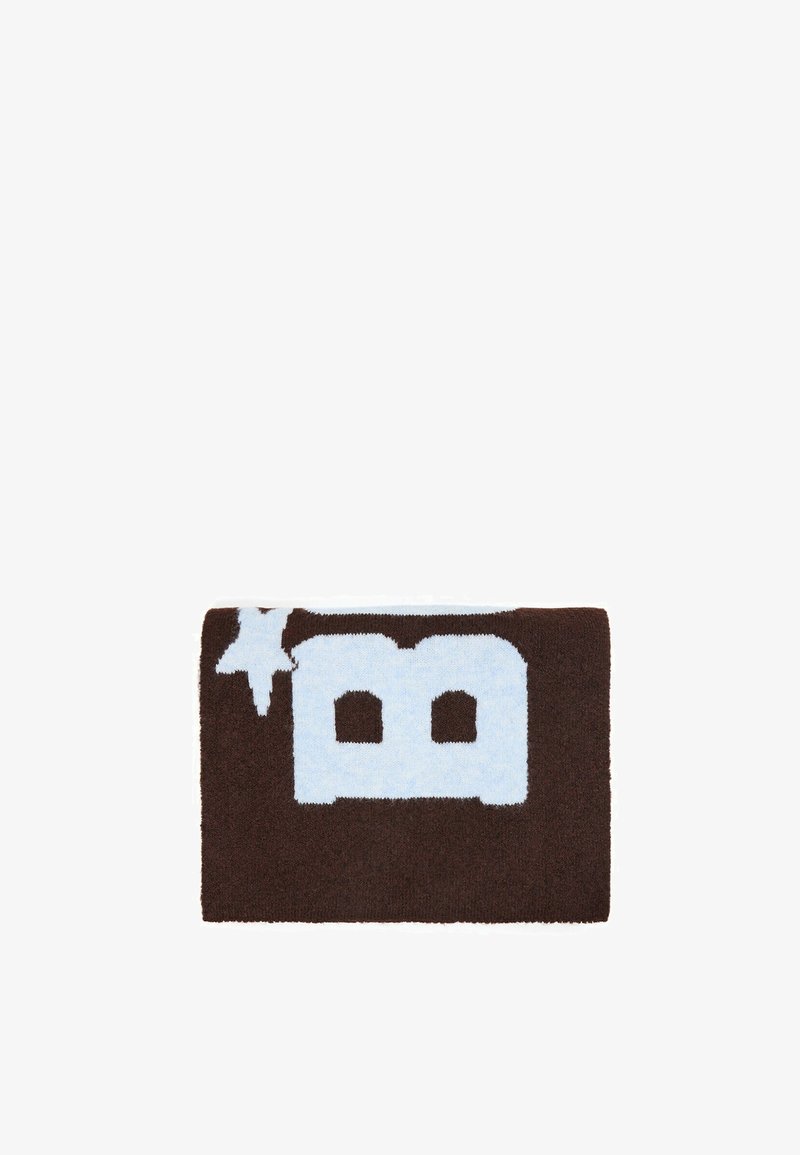 Pièce tricotée rectangulaire marron avec une grande lettre majuscule bleue claire "B" et une forme d’étoile dans le coin supérieur gauche.