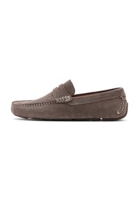 Mocasines de ante gris con suela plana, detalles de costura y una correa en el empeine. Textura suave con diseño de punta redondeada.