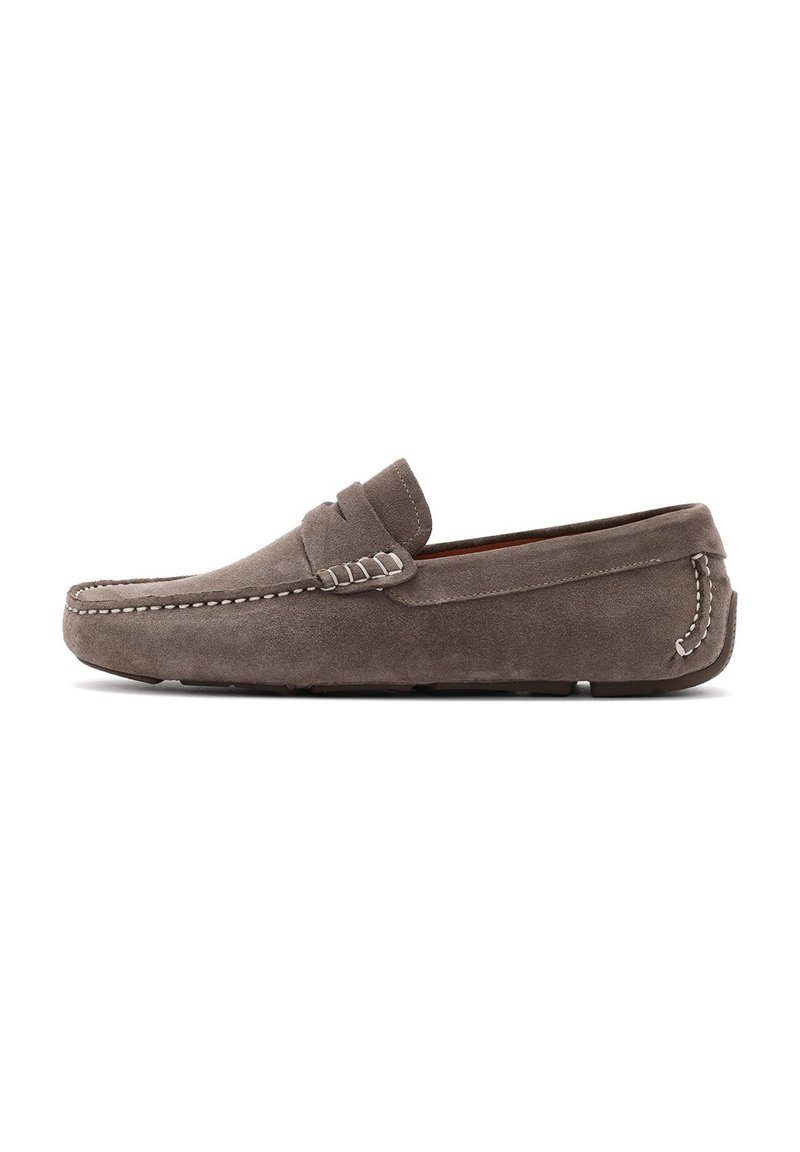 Mocasines de ante gris con suela plana, detalles de costura y una correa en el empeine. Textura suave con diseño de punta redondeada.