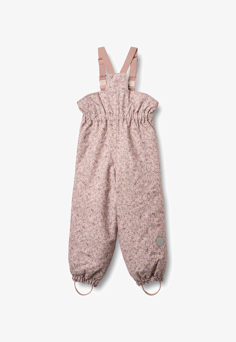 Rosa overall med blommönster, axelband, resår i midjan och avsmalnande ben. Har öglor vid fållen och en rund logodetalj.