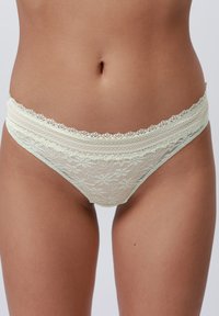 Thong mint verde din dantelă cu model floral, talie elastică cu margine ondulată și o textură moale, transparentă.
