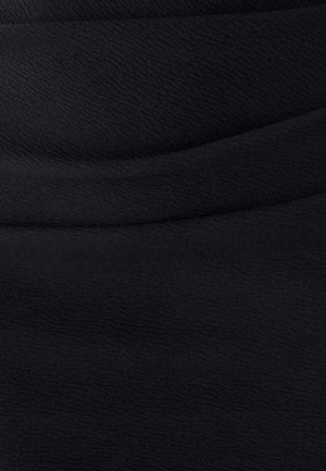 Juodas tekstūruotas audinys su subtiliomis bangų formomis, pasižymintis lygiu, minkštu paviršiumi, tinkamu drabužiams ar apmušalams.