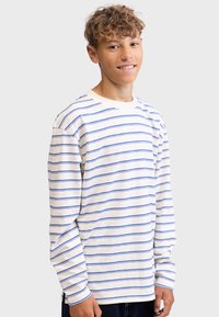 Long-sleeve shirt in cream with blue stripes, made of soft cotton. Features a crew neckline and relaxed fit. Adjustable cuffs.