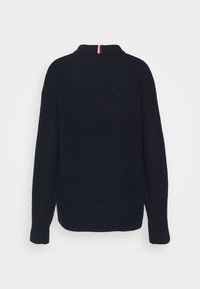 Pull côtelé bleu foncé avec un col montant et une bande rouge et blanche au niveau du col, manches longues et coupe décontractée.