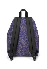 Mochila de color púrpura oscuro con puntos dorados. Cuenta con correas negras ajustables y un asa superior. Textura de tela suave con soporte acolchado.