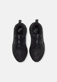 Schwarze Sportschuhe mit einer strukturierten Mesh-Oberfläche, ausgestattet mit einer Zuglasche, Schnürdesign und einem dezenten geometrischen Muster an den Seiten.