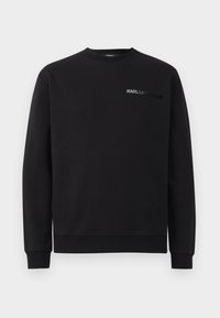 Felpa nera realizzata in un tessuto misto cotone. Caratterizzata da un collo a giro, maniche lunghe, polsini a costine e un logo tonale "KARL LAGERFELD" sul petto.