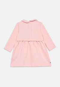 Vestido rosa de manga larga con cuello, cierre de botón en la parte de atrás y falda con volantes. Hecho de tela suave, diseño sencillo.