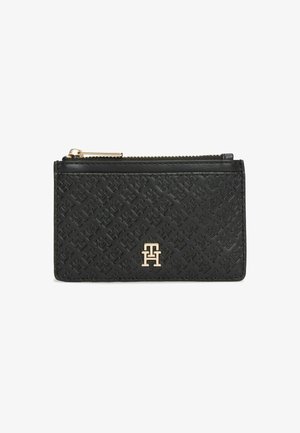 Porte-cartes en cuir noir avec motif embossé, fermeture éclair dorée et emblème de logo doré sur le devant.