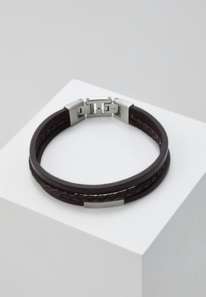 Bracelet noir en cuir à double couche avec détail tressé et fermoir rectangulaire en argent, présenté sur un socle blanc.
