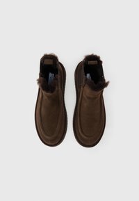 Bruine suède enkellaarsjes met bontafwerking, afgeronde neus en gevoerde zool, met een naadloos ontwerp en minimalistische stijl.