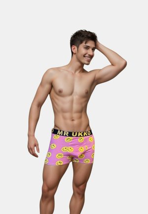 Shorts de boxeur pour hommes en tissu rose avec des motifs de visages souriants jaunes, dotés d'une ceinture élastique noire portant la marque "MR UKKO". Matériau doux et extensible.