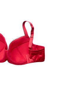 Czerwony biustonosz z gładkiej tkaniny, z wsparciem na fiszbinach, z usztywnianymi miseczkami, ozdobiony falbanką wzdłuż górnej krawędzi oraz regulowanymi ramiączkami z złotymi detalami.