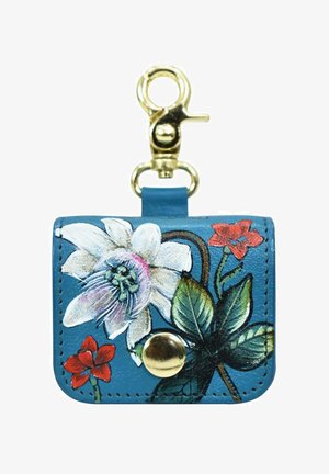 Blauwe leren sleutelhanger tasje met bloemontwerp; bevat een witte bloem en rode accenten; gouden drukknoop en clip voor bevestiging.