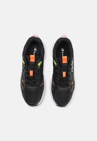 Scarpe da ginnastica nere realizzate con materiali in rete e sintetici, con accenti arancioni e verde neon, suole bianche e un tab in rosa sul tallone.