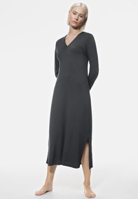 Langdurige, donkergrijze jurk van zachte stof, met een V-hals, zijsplitten en een aansluitend ontwerp, die tot halverwege de kuit reikt.